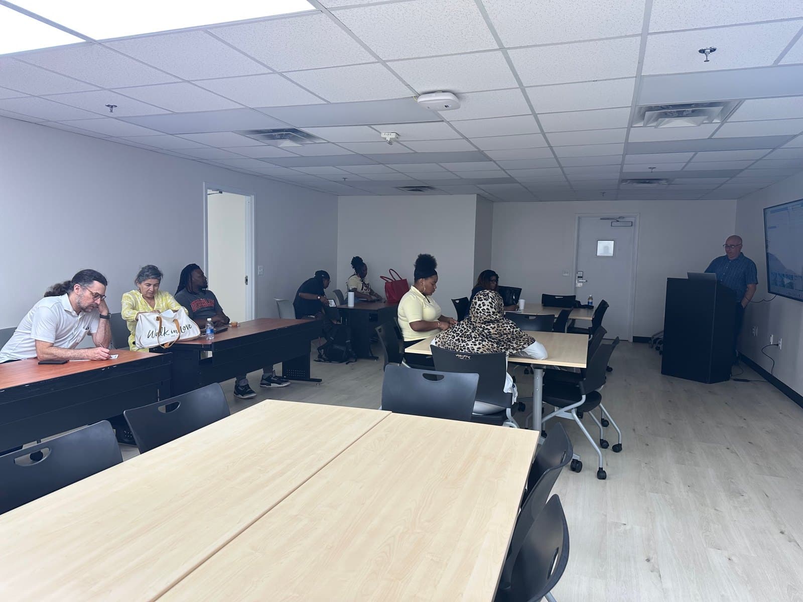 Educators meet around classroom tables for a group session.