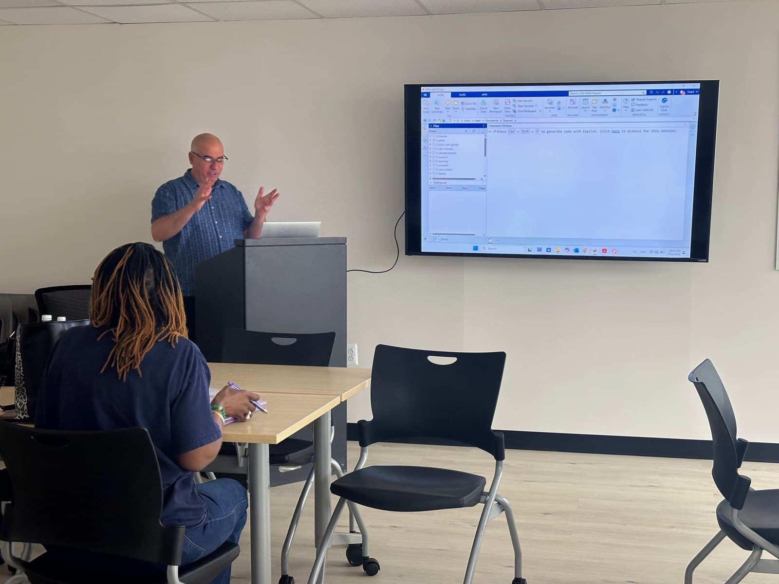 A facilitator leads a session with a shared display.