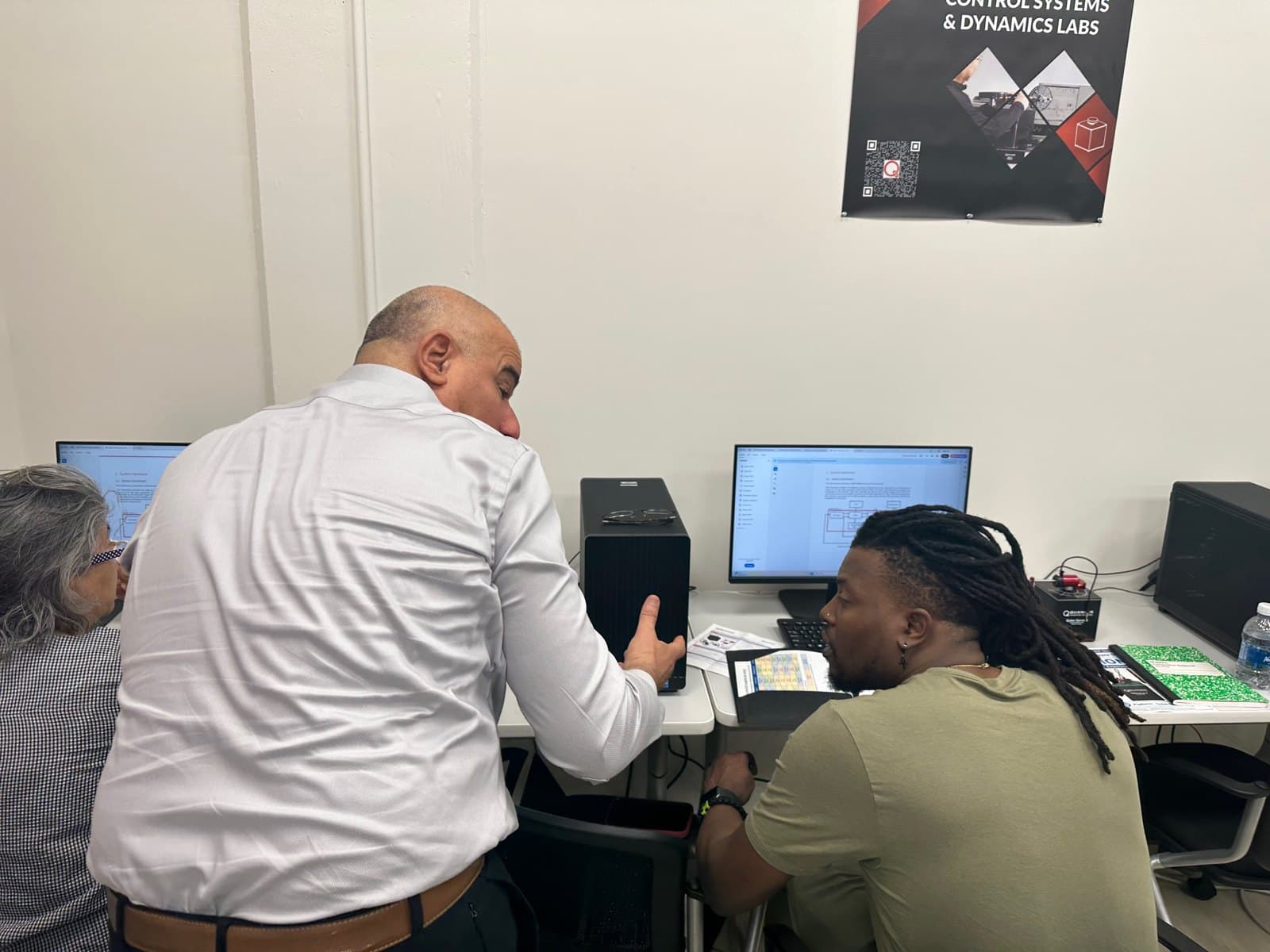 An educator and a facilitator discuss a computer-based laboratory activity.