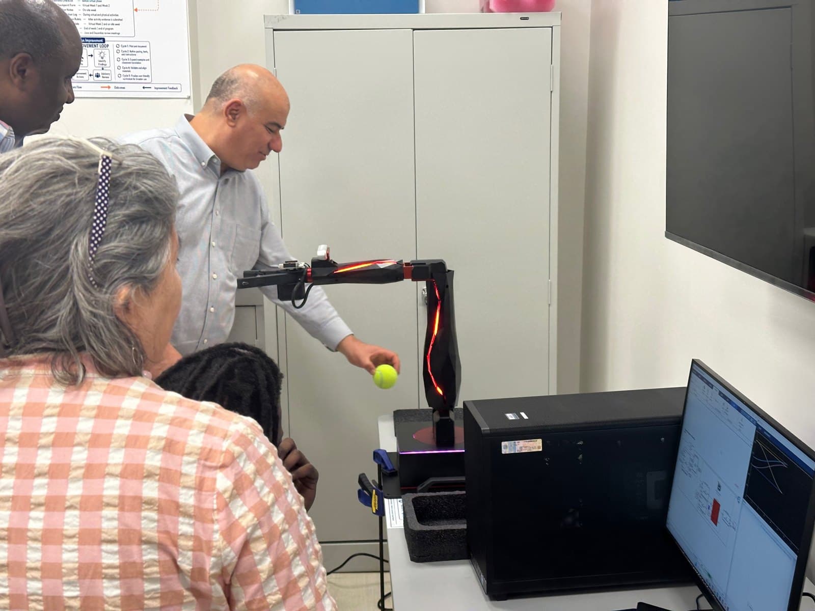 Educators investigate a QArm workstation.