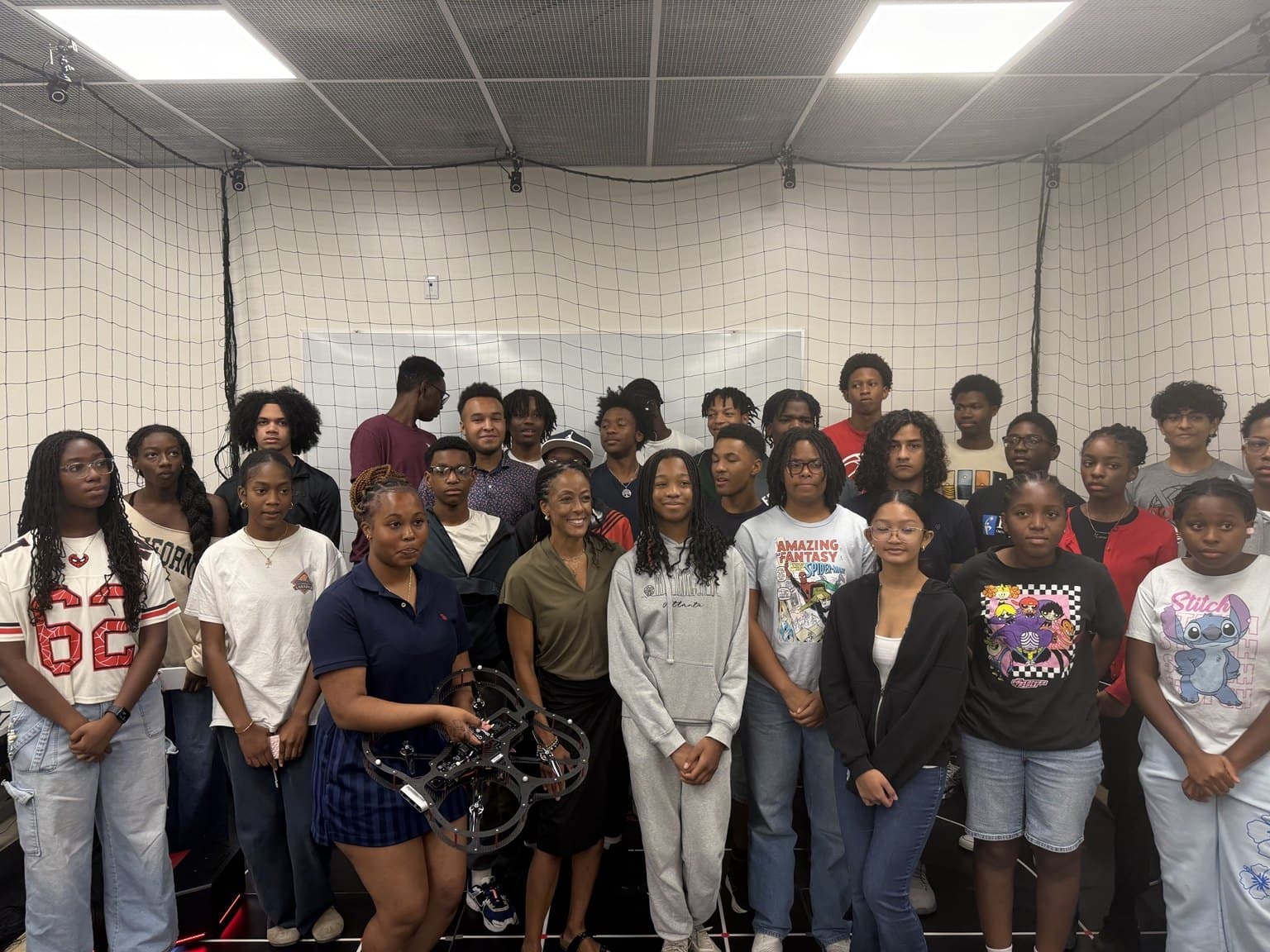 A larger group gathers for a photograph inside the netted AVRC research studio.