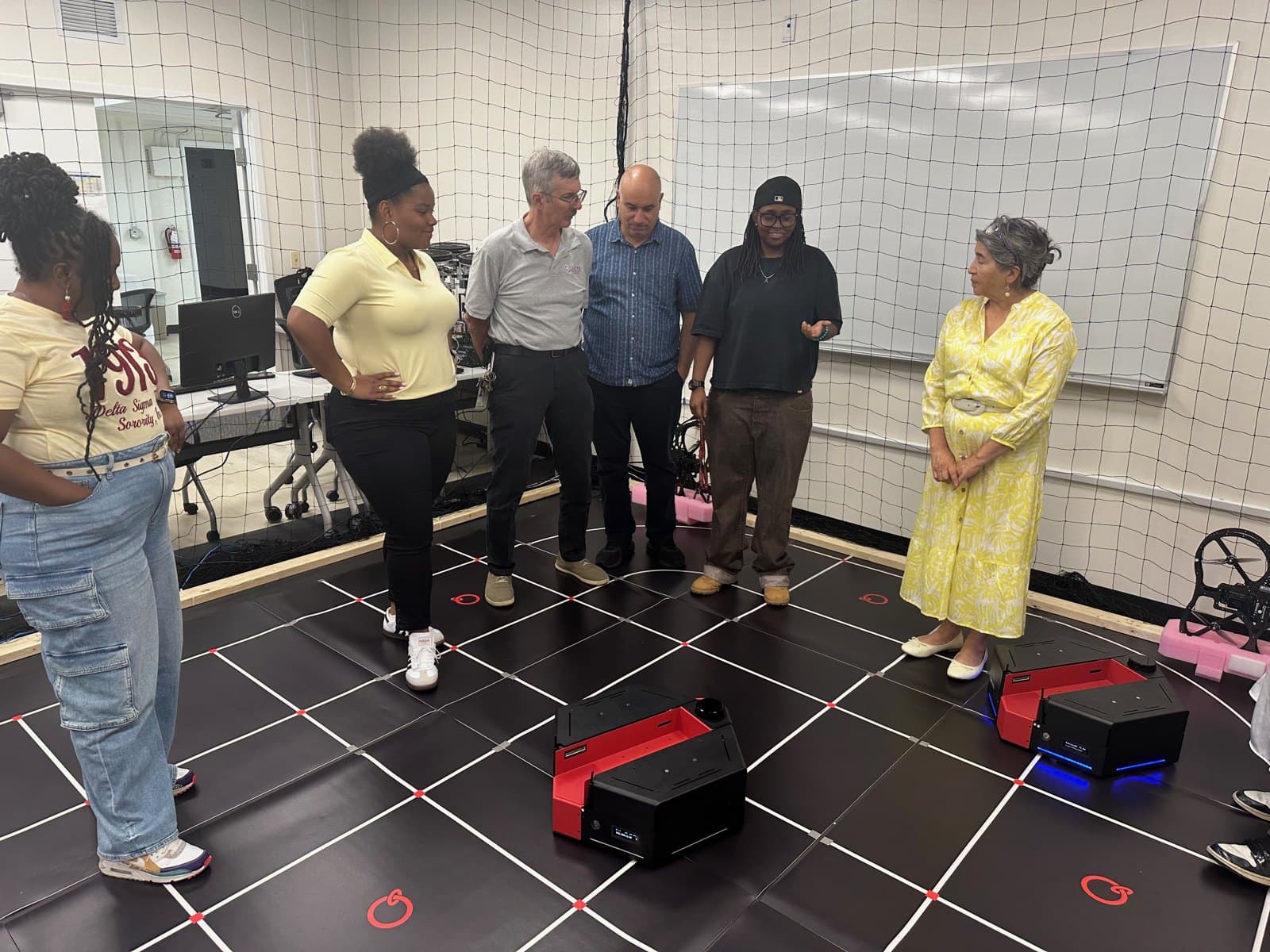 RAOP 2026 participants and facilitators, including Fadel Lashhab (center, in blue), beside the mobile robotics platforms.